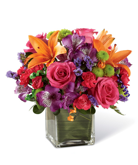 Hot pink roses and orange Asiatic Lilies are vibrant and fun surrounded by purple Peruvian Lilies, hot pink mini carnations, green button poms, purple statice