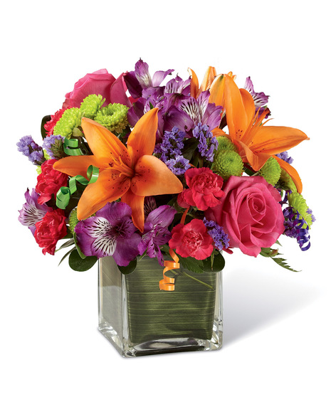 Hot pink roses and orange Asiatic Lilies are vibrant and fun surrounded by purple Peruvian Lilies, hot pink mini carnations, green button poms, purple statice