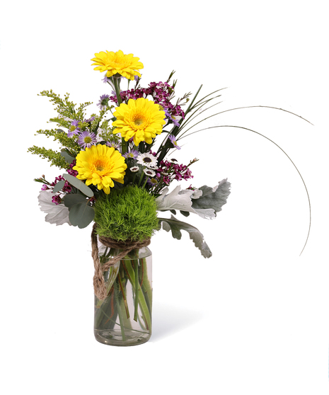 mini-gerbera daisies, bear grass, and golden aster in milk bottle-style vase